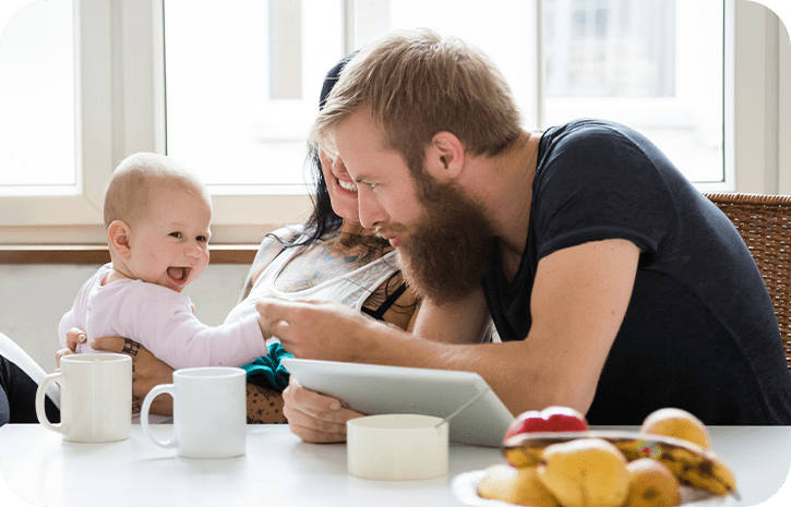 Mutter Vater Kind lachen am Tisch | Babyservice