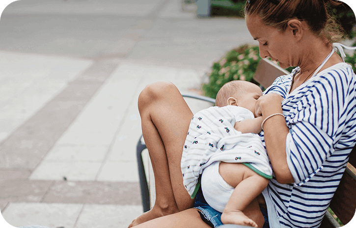 Mutter beim Stillen auf einer Sitzbank | Babyservice 